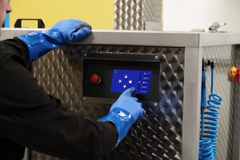 Mann zeigt das Display des Ultraschallreinigungsgeräts Sonickleen Eco von Safetykleen. 