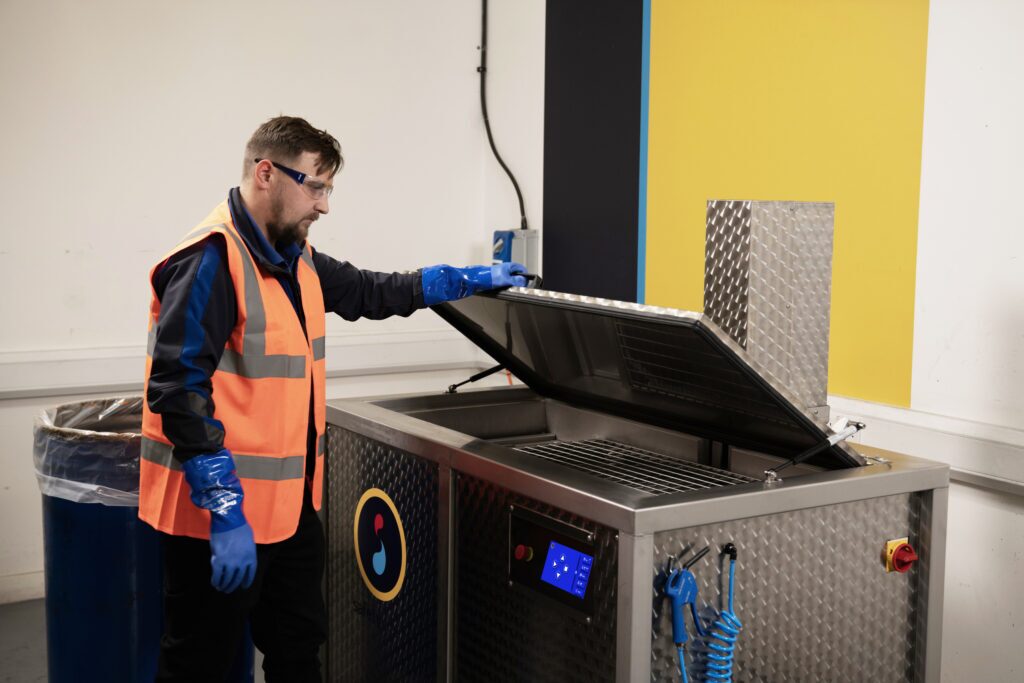 Safetykleen service representative standing next to and Ultrasonic parts cleaning, the Sonickleen Eco