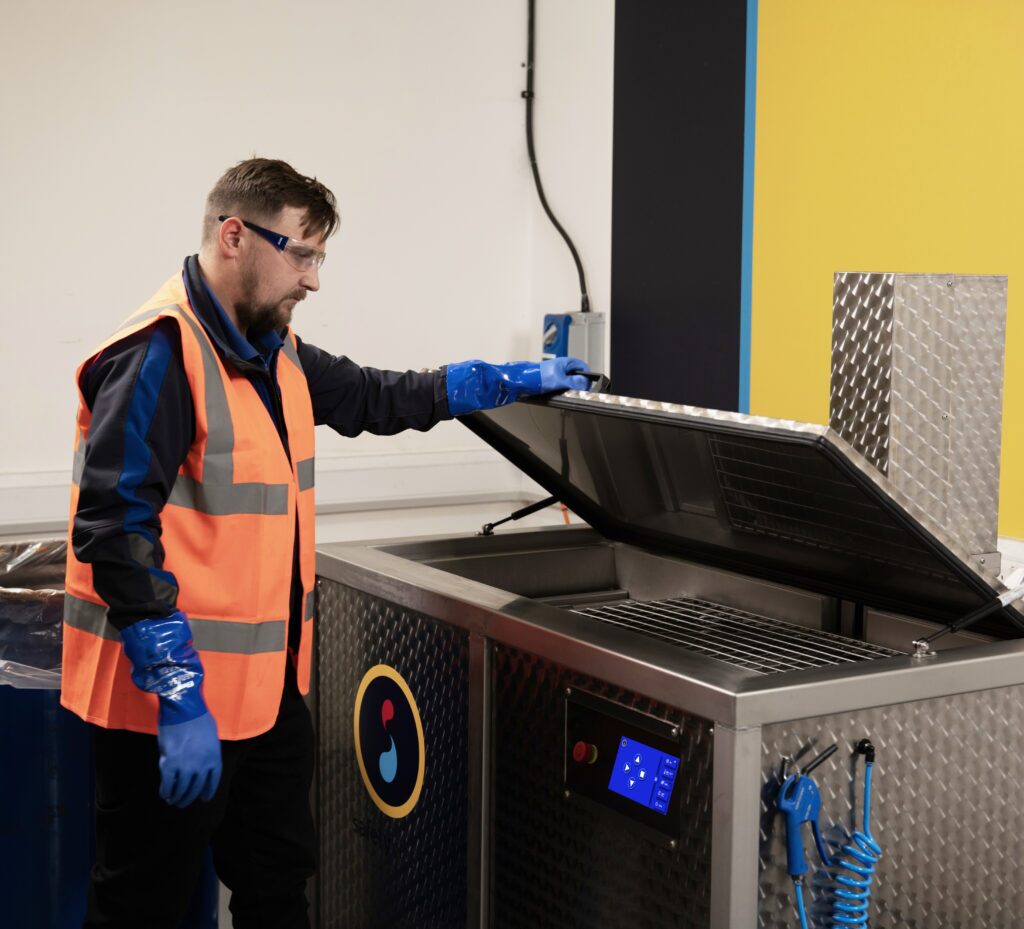 Safetykleen service representative standing next to and Ultrasonic parts cleaning, the Sonickleen Eco