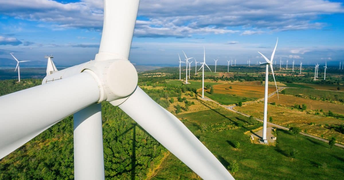 Wind turbines in a green field, representing sustainable manufacturing